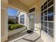 Inviting front porch featuring a large window, glass front door, and green landscaping providing a warm welcome at 24156 Buckingham Way, Punta Gorda, FL 33980