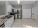 Open kitchen features stainless steel appliances, granite countertops, tile flooring, and white cabinets providing style at 24156 Buckingham Way, Punta Gorda, FL 33980