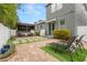 Private backyard featuring a brick patio, cozy pergola with seating, and manicured landscaping for relaxation and entertainment at 7602 S Desoto St, Tampa, FL 33616