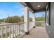 Covered balcony with white railings, columns and wood flooring, offering a relaxing outdoor space at 7602 S Desoto St, Tampa, FL 33616