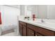 Bathroom with double sinks, wood cabinets and white counter tops, plus a shower with a curtain at 7602 S Desoto St, Tampa, FL 33616