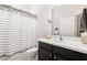 Clean bathroom with striped shower curtain, black vanity with white countertop, and modern fixtures at 7602 S Desoto St, Tampa, FL 33616