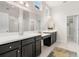 Modern bathroom with double vanity, dark cabinets, white countertops, and walk-in shower at 7602 S Desoto St, Tampa, FL 33616
