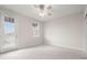 Bright bedroom featuring neutral carpet, white walls, ceiling fan and two bright window and glass door at 7602 S Desoto St, Tampa, FL 33616