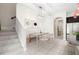 Bright dining area featuring modern light fixture, a dining table with seating, next to the staircase at 7602 S Desoto St, Tampa, FL 33616