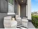 Cozy front porch featuring gray and white wicker furniture, a black and white rug, and gray walls at 7602 S Desoto St, Tampa, FL 33616