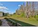 A view of the backyard with manicured landscaping, leading up to the community landscape at 1123 Emerald Dunes Dr, Sun City Center, FL 33573
