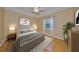 Beautiful main bedroom with ceiling fan, art, and hard wood flooring, creating a relaxing atmosphere at 1123 Emerald Dunes Dr, Sun City Center, FL 33573