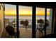 Relaxing balcony featuring seating and a stunning ocean view at sunset at 16330 Gulf Blvd # 306, Redington Beach, FL 33708