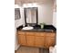 Bathroom featuring a vanity with a black countertop and honey-colored wood cabinets, plus neutral colored walls at 16330 Gulf Blvd # 306, Redington Beach, FL 33708