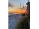 Lovely view of the beach with a sunset and beach grass in the foreground at 16330 Gulf Blvd # 306, Redington Beach, FL 33708