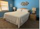 Cozy bedroom features a comfortable bed, side tables, and nautical themed wall decor against a blue wall at 16330 Gulf Blvd # 306, Redington Beach, FL 33708