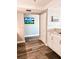Hallway featuring wood-look floors, coastal artwork, and access to the kitchen and other rooms at 16330 Gulf Blvd # 306, Redington Beach, FL 33708