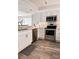 Modern kitchen featuring stainless steel appliances, white cabinetry, and wood-look flooring at 16330 Gulf Blvd # 306, Redington Beach, FL 33708