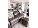 Living room featuring wood-look floors, comfortable leather seating, and beach-themed decor at 16330 Gulf Blvd # 306, Redington Beach, FL 33708