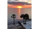 Breathtaking sunset view over the ocean from a patio with palm trees and comfortable outdoor seating at 16330 Gulf Blvd # 306, Redington Beach, FL 33708