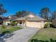 Well-maintained single-story home with a neat lawn and a convenient two-car garage under a clear blue sky at 17413 Eagle Trace Dr, Brooksville, FL 34604