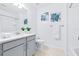 Bright bathroom with vanity, white countertop, and a shower featuring blue floral art on the wall at 31349 Cabana Rye Ave, San Antonio, FL 33576