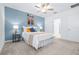 Bedroom with neutral carpet, ceiling fan and serene accent wall leading to ensuite bathroom at 31349 Cabana Rye Ave, San Antonio, FL 33576