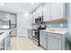 Well-lit kitchen with light gray cabinets, stainless steel appliances, and blue patterned backsplash at 31349 Cabana Rye Ave, San Antonio, FL 33576