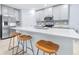 Close-up of an island featuring bright quartz countertops, a sink, seating and light gray cabinetry at 31349 Cabana Rye Ave, San Antonio, FL 33576