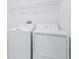 Bright laundry room with full sized washer and dryer and upper shelf for storage at 31349 Cabana Rye Ave, San Antonio, FL 33576
