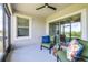 Screened patio with comfortable seating and a ceiling fan overlooking a lush green landscape at 31349 Cabana Rye Ave, San Antonio, FL 33576