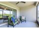 Screened patio with comfortable seating and a ceiling fan overlooking a lush green landscape at 31349 Cabana Rye Ave, San Antonio, FL 33576