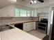 Bright kitchen featuring white cabinetry, tiled countertops, and stainless steel appliances at 6170 7Th N Ave, St Petersburg, FL 33710