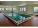 Indoor swimming pool with chrome ladders and tile surround at 6170 7Th N Ave, St Petersburg, FL 33710