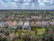 Aerial view of home in neighborhood with mature trees and lawn at 6324 Magnolia Trails Ln, Gibsonton, FL 33534
