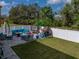 This backyard features a gray paver patio with a blue outdoor seating set and a white vinyl fence at 6324 Magnolia Trails Ln, Gibsonton, FL 33534