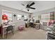 A bonus room with carpet flooring, a ceiling fan, a built in desk and a wall of windows at 6324 Magnolia Trails Ln, Gibsonton, FL 33534