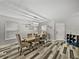Bright dining room features wood-look floors, a modern chandelier, seating for six, and white walls at 6324 Magnolia Trails Ln, Gibsonton, FL 33534