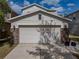 Two-story home with a two-car garage featuring stone accents and exterior lighting at 6324 Magnolia Trails Ln, Gibsonton, FL 33534