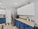 Bright kitchen featuring stainless steel appliances and blue lower cabinets with light countertops at 6324 Magnolia Trails Ln, Gibsonton, FL 33534