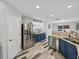 Well-lit kitchen with stainless steel appliances, blue cabinets, and an open view to the backyard at 6324 Magnolia Trails Ln, Gibsonton, FL 33534