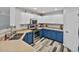 Well-lit kitchen featuring stainless steel appliances, blue lower cabinets, and ample counter space at 6324 Magnolia Trails Ln, Gibsonton, FL 33534