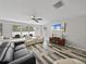 Inviting living room featuring a large TV, ample seating, and natural light from multiple windows at 6324 Magnolia Trails Ln, Gibsonton, FL 33534