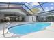 Private screened-in pool with clear water, tile trim, and home exterior at 705 Spanish Main Dr, Apollo Beach, FL 33572