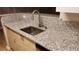 Kitchen with granite countertops, stainless steel sink, and wood cabinetry at 8609 Mallard Reserve Dr # 103, Tampa, FL 33614