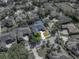 Aerial view of a property with a dark roof surrounded by green trees and neighboring houses in the community at 1111 Carriage Park Dr, Valrico, FL 33594