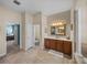 Bathroom featuring tile flooring, a double vanity, and a soaking tub; bedroom in the background at 1111 Carriage Park Dr, Valrico, FL 33594