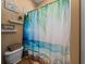 Tropical themed bathroom featuring a vanity, toilet and shower with a beach scene shower curtain at 1111 Carriage Park Dr, Valrico, FL 33594