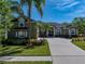 Beautiful curb appeal showcased by this home's lush landscaping, palm trees, and extra-long driveway at 1111 Carriage Park Dr, Valrico, FL 33594