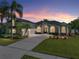 Stunning exterior shot showcasing a well-manicured lawn and a beautiful residence with a two-car garage at 1111 Carriage Park Dr, Valrico, FL 33594