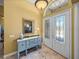 Bright foyer showcasing a decorative table, mirror, tile flooring, and arched window above double front doors at 1111 Carriage Park Dr, Valrico, FL 33594