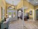 Inviting foyer with elegant tile flooring, arched doorways, and decorative glass front doors at 1111 Carriage Park Dr, Valrico, FL 33594