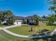 Expansive lawn and landscaping highlight this homes curb appeal with palm trees and an extended drive at 1111 Carriage Park Dr, Valrico, FL 33594