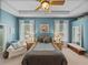 Comfortable main bedroom features a tray ceiling, soft lighting, and a cozy armchair at 1111 Carriage Park Dr, Valrico, FL 33594